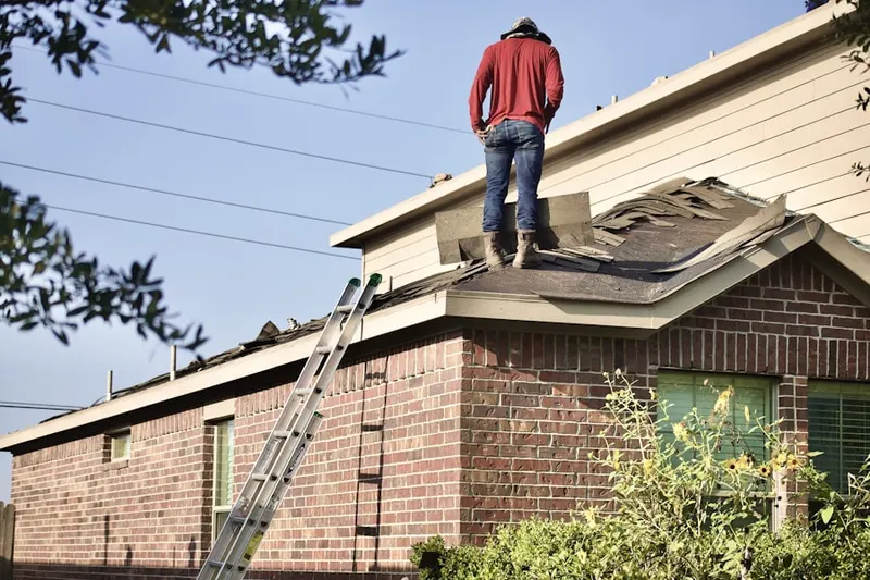 Professional roofer working on a residential roof in Merriam Park West
